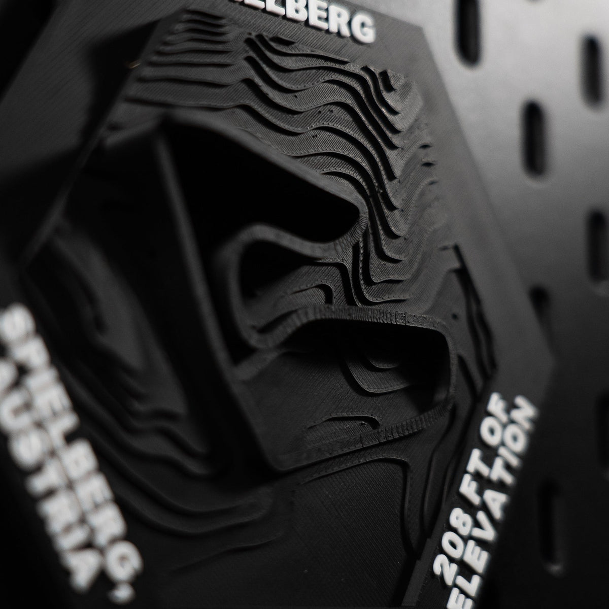 Spielberg hex at a raking angle, stacked print layers reading as bare contour lines