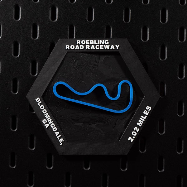 Roebling Road Raceway hex flat on black pegboard, blue circuit loop on black terrain