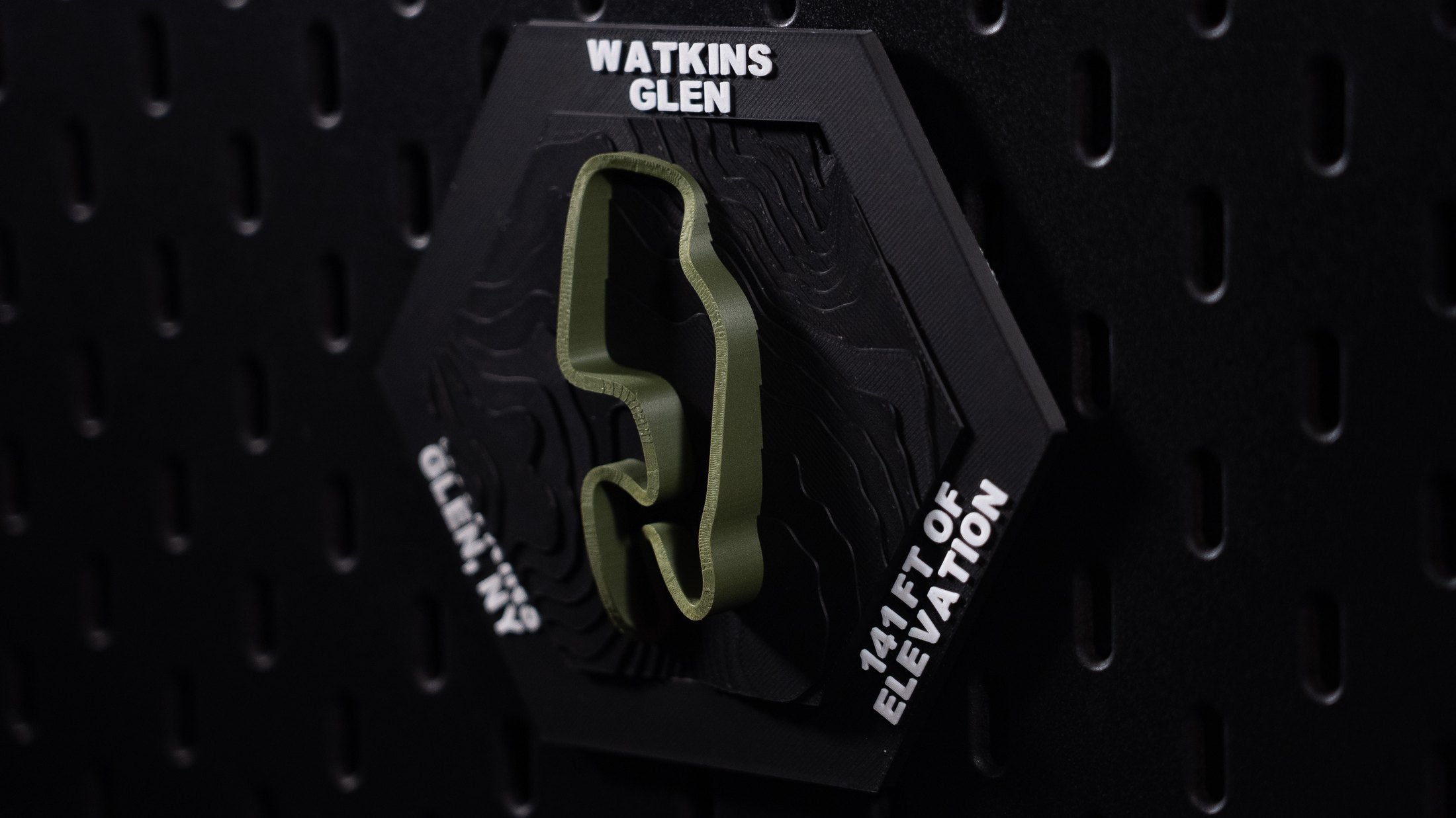 Watkins Glen hex on black pegboard, olive circuit ribbon raised over contour-terraced terrain