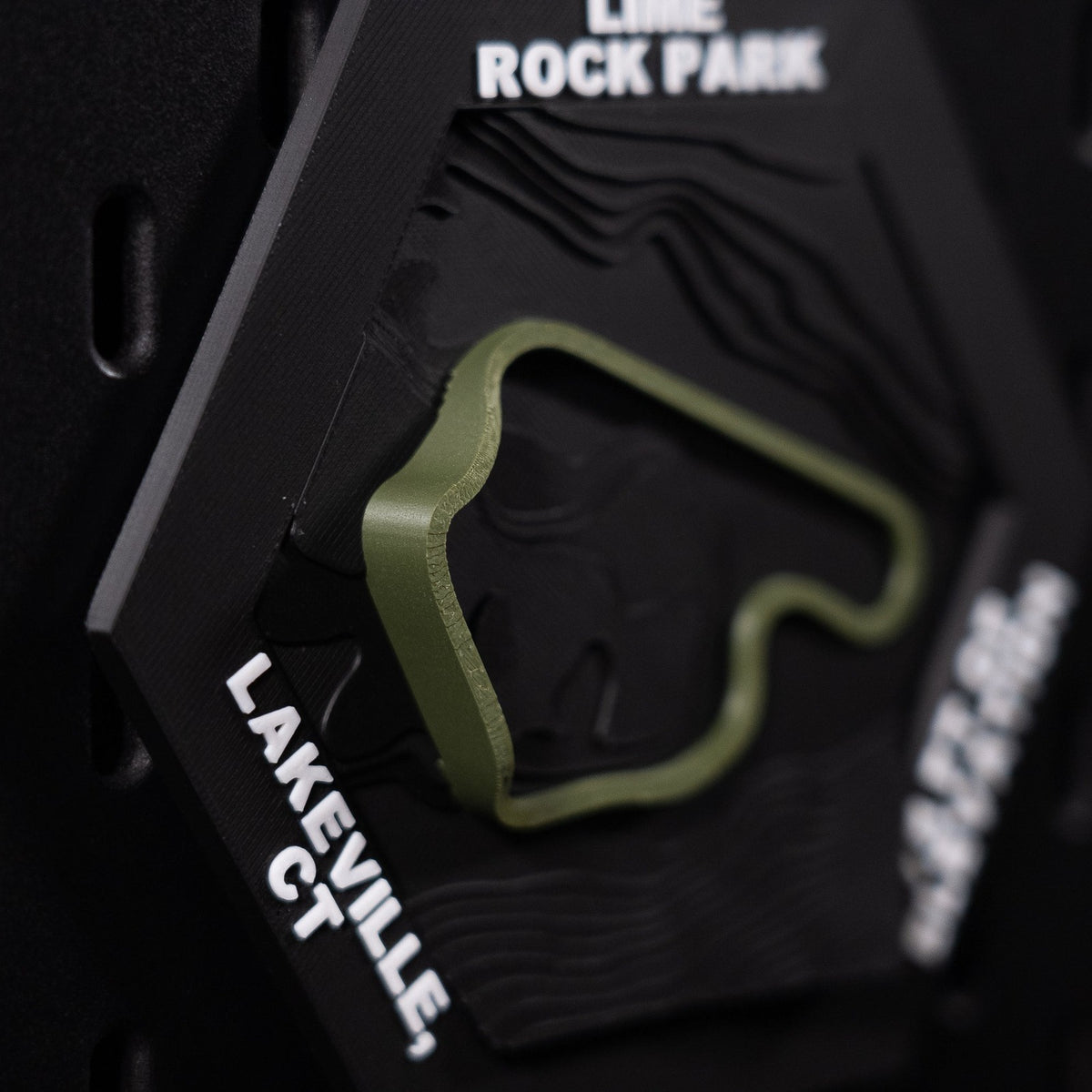 Lime Rock Park hex angled left, olive loop above bold white lettering reading Lakeville, CT