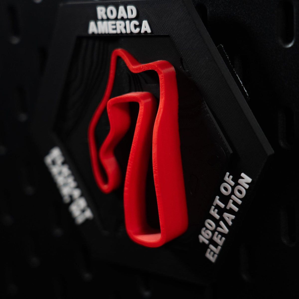 Road America hex angled, long red straights in relief beside the engraved 160 ft of elevation