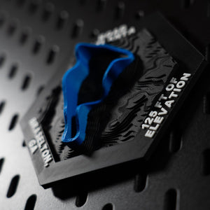 Road Atlanta hex lying almost flat under raking side light, blue loop and hex rim in relief