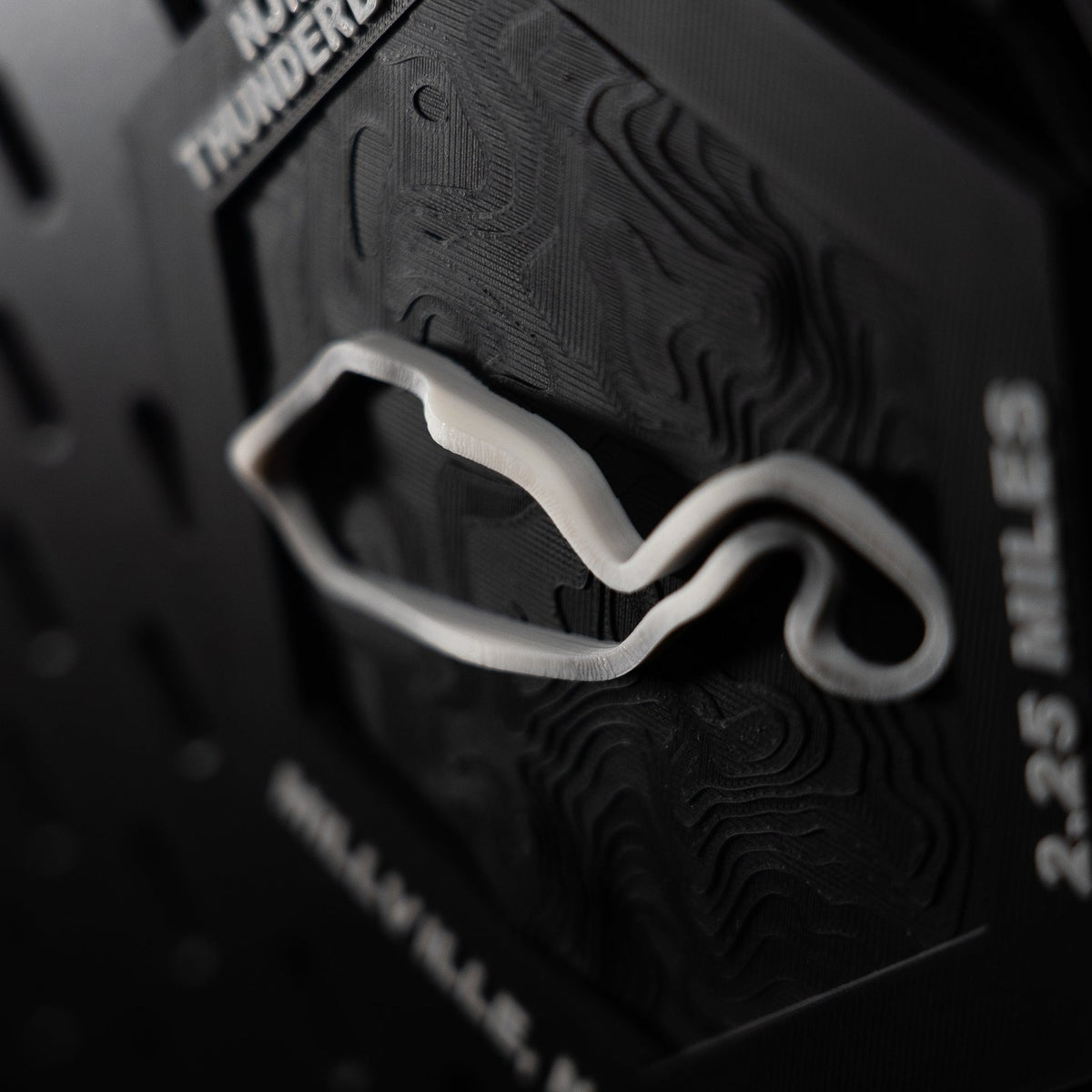 NJMP Thunderbolt hex angled, white lap in relief beside the engraved 2.25 miles