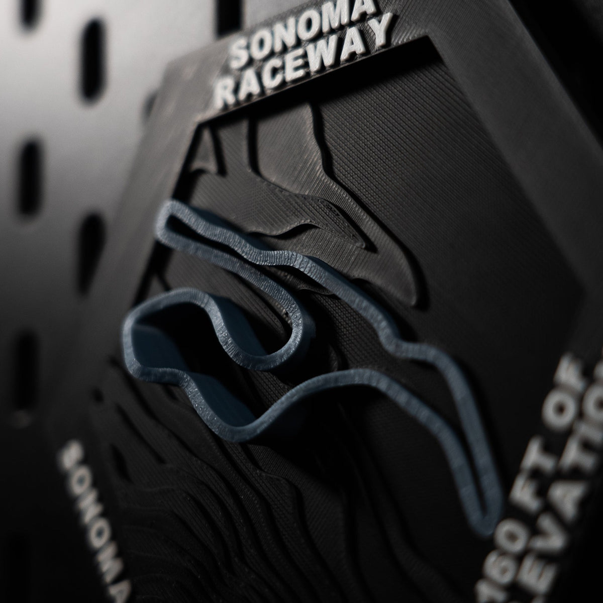 Sonoma Raceway hex at a steep angle, blue track threading heavily terraced hillside contours