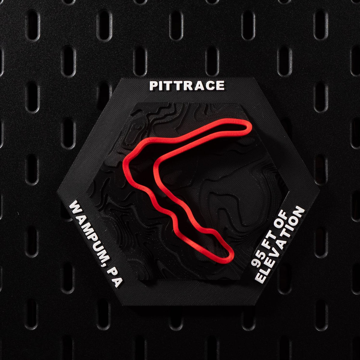 PittRace hex flat on black pegboard, red circuit loop raised over black contour terrain