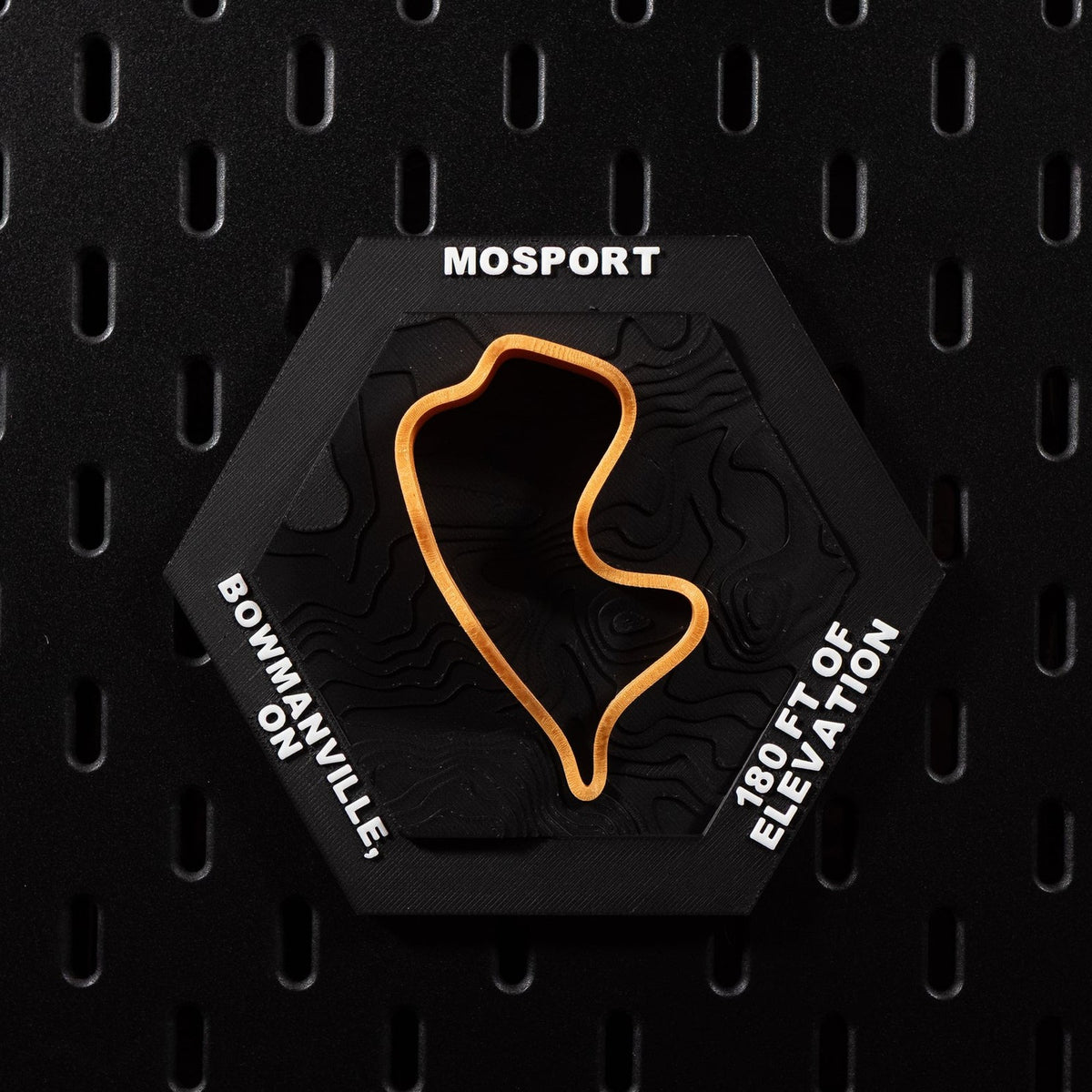 Mosport hex flat on black pegboard, bright orange circuit loop over black contour terrain