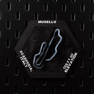 Mugello hex flat on black pegboard, slate blue circuit loop on dark terraced terrain