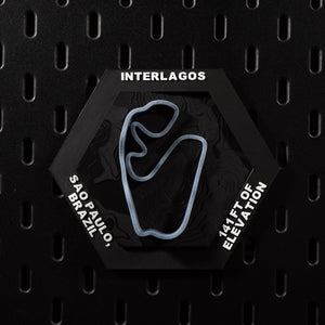 Interlagos hex flat on black pegboard, pale blue track loop set into dark contour terrain