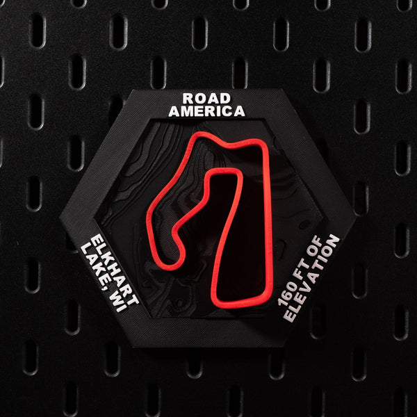 Road America hex flat on black pegboard, red circuit loop over dark contour terrain