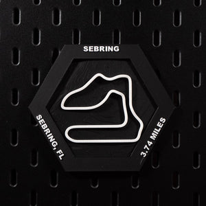 Sebring hex flat on black pegboard, white circuit loop over black contour terrain