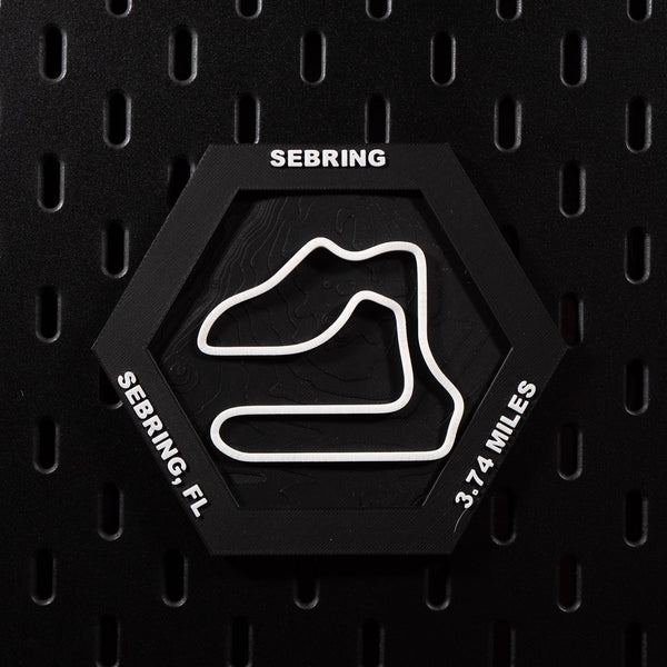Sebring hex flat on black pegboard, white circuit loop over black contour terrain