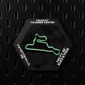 Polecat Training Center hex flat on black pegboard, bright green circuit loop on terraced terrain