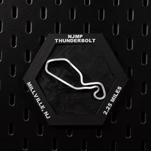 NJMP Thunderbolt hex flat on black pegboard, white circuit loop over black contour terrain