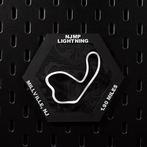 NJMP Lightning hex flat on black pegboard, white circuit loop bright against black terrain
