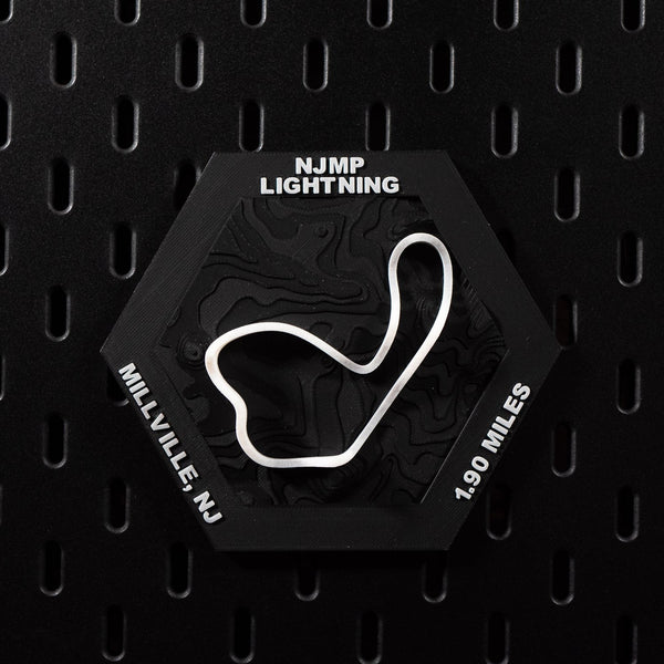 NJMP Lightning hex flat on black pegboard, white circuit loop bright against black terrain